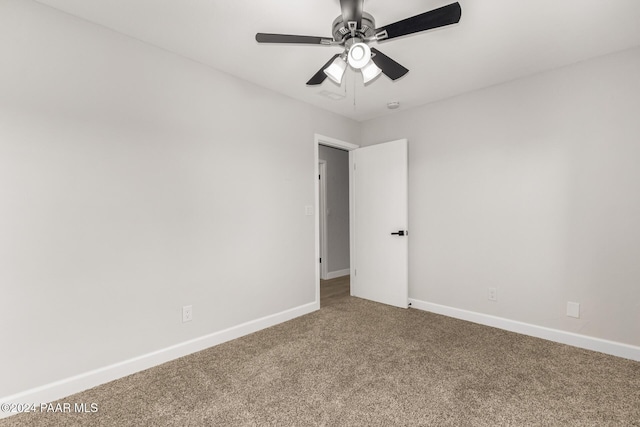 carpeted spare room featuring ceiling fan