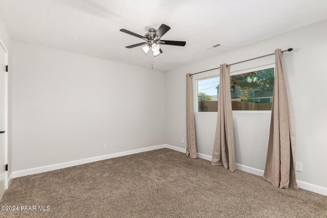 carpeted spare room with ceiling fan