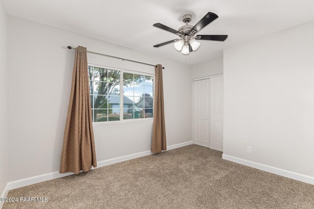 carpeted spare room with ceiling fan