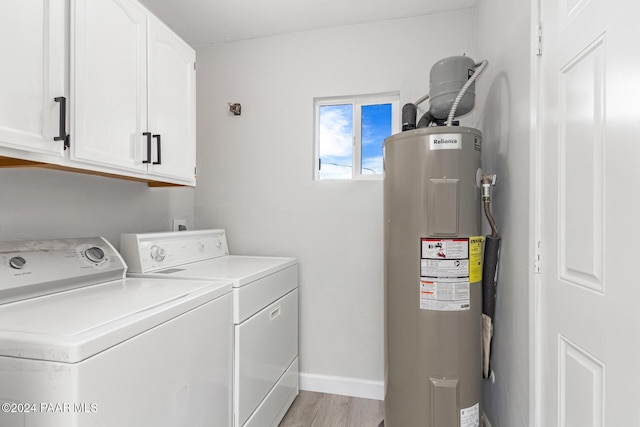 washroom featuring electric water heater, cabinets, independent washer and dryer, and light hardwood / wood-style flooring