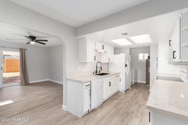 kitchen with white appliances, sink, separate washer and dryer, light hardwood / wood-style floors, and white cabinetry