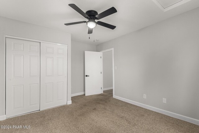 unfurnished bedroom with carpet, a closet, and ceiling fan