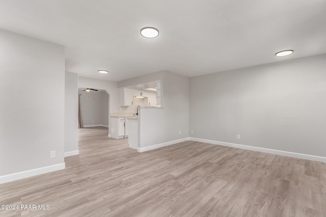 unfurnished living room featuring ceiling fan and light hardwood / wood-style flooring