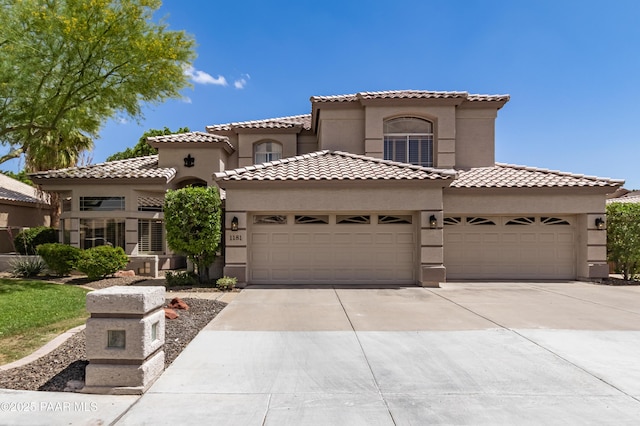 mediterranean / spanish house featuring stucco siding, a tile roof, concrete driveway, and a garage