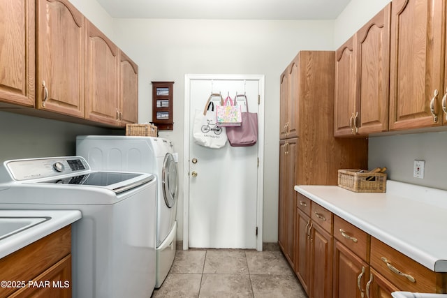 clothes washing area with separate washer and dryer and cabinet space
