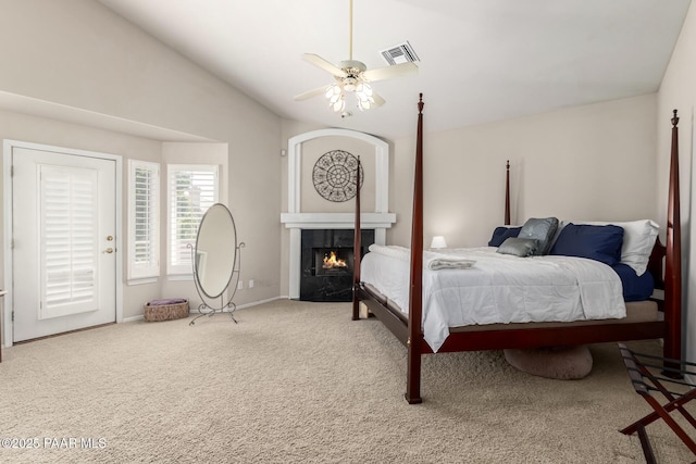 bedroom featuring a warm lit fireplace, visible vents, a ceiling fan, baseboards, and carpet flooring