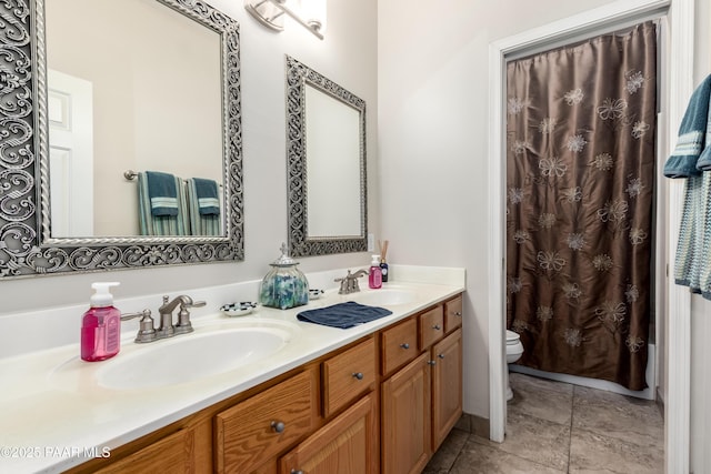 full bath featuring a sink, double vanity, and toilet