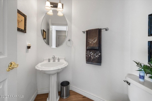 bathroom with sink, hardwood / wood-style floors, and toilet