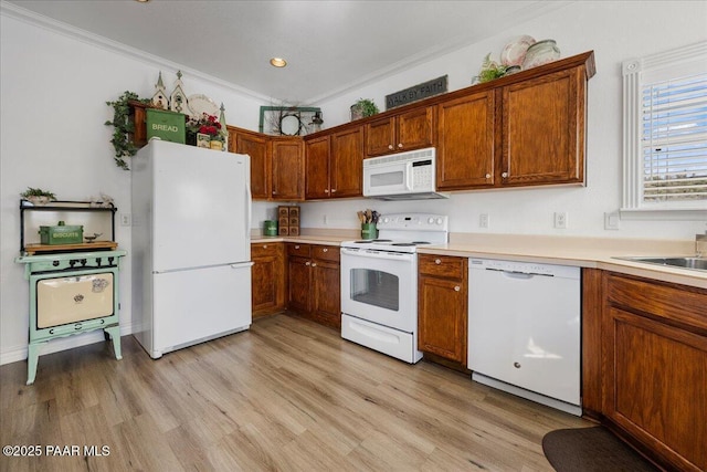 kitchen with white appliances, light hardwood / wood-style floors, and ornamental molding