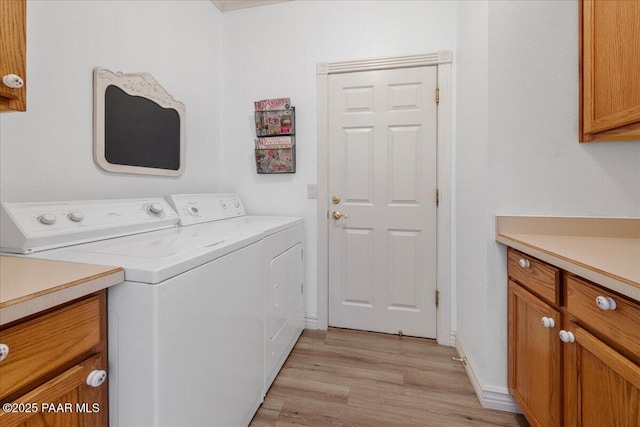 laundry room with light hardwood / wood-style floors, cabinets, and independent washer and dryer