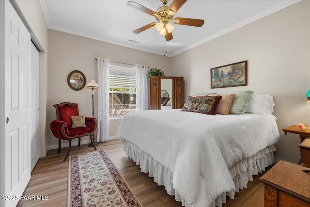 bedroom featuring a closet, ceiling fan, hardwood / wood-style floors, and crown molding