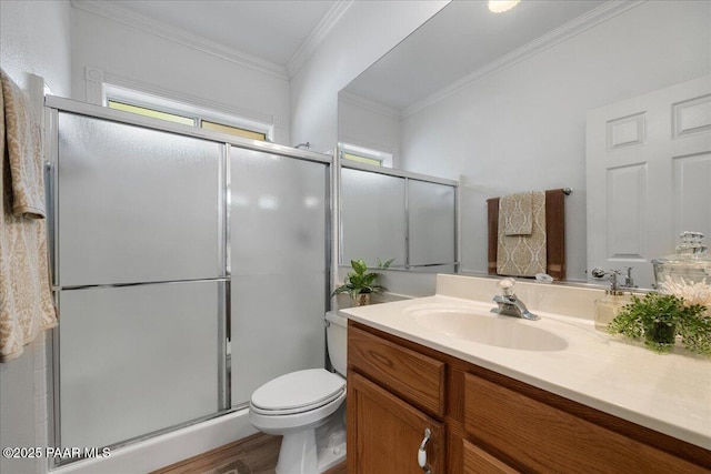 bathroom featuring crown molding, a shower with door, hardwood / wood-style flooring, toilet, and vanity