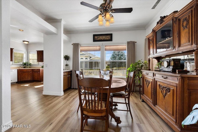 dining area featuring light hardwood / wood-style floors, crown molding, and ceiling fan