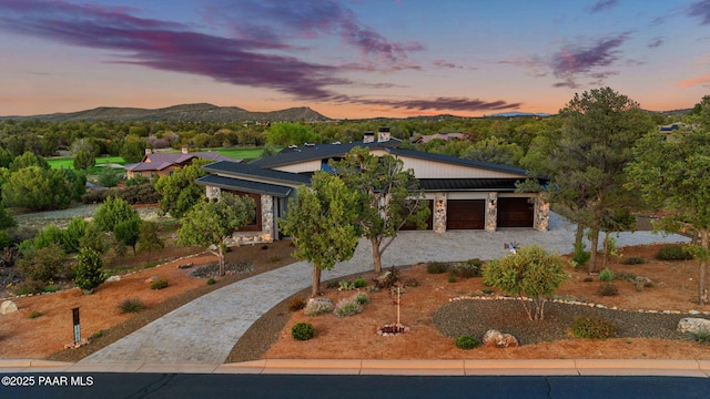 15425 N Talking Rock Ranch Rd, Prescott, AZ 86305 - view of front of house featuring decorative driveway, a mountain view, stone siding, an attached garage, and a chimney