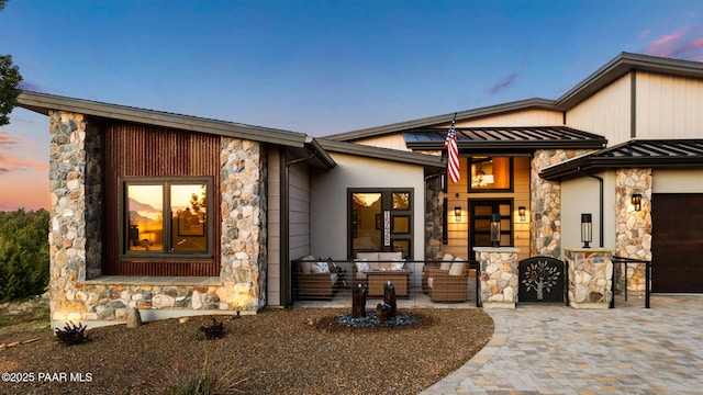 15425 N Talking Rock Ranch Rd, Prescott, AZ 86305 - view of front of home with stone siding, a standing seam roof, a garage, a metal roof, and driveway