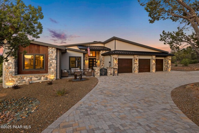 15425 N Talking Rock Ranch Rd, Prescott, AZ 86305 - view of front facade with stone siding, decorative driveway, an attached garage, a standing seam roof, and a metal roof