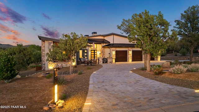 15425 N Talking Rock Ranch Rd, Prescott, AZ 86305 - contemporary house featuring a standing seam roof, decorative driveway, an attached garage, stone siding, and a metal roof