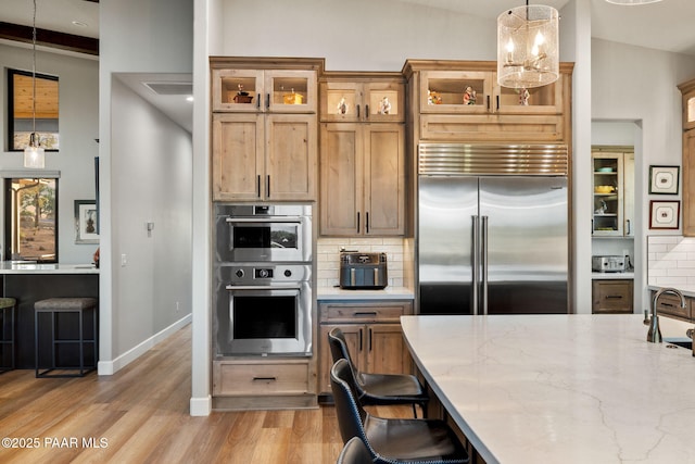 15425 N Talking Rock Ranch Rd, Prescott, AZ 86305 - kitchen featuring stainless steel appliances, decorative backsplash, pendant lighting, light wood-style floors, and glass insert cabinets