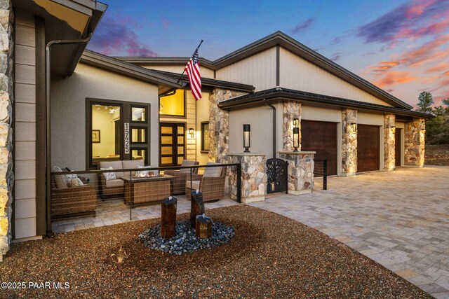 15425 N Talking Rock Ranch Rd, Prescott, AZ 86305 - view of front facade with stone siding, an outdoor living space, decorative driveway, and a garage