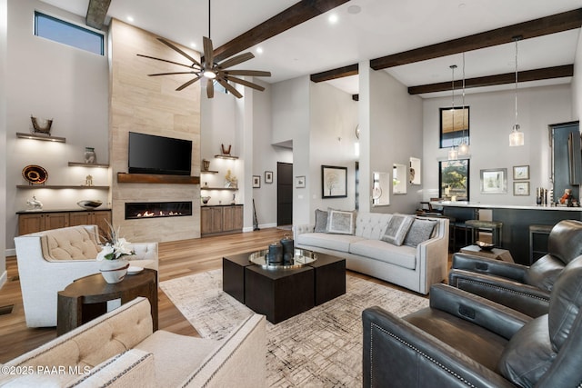 15425 N Talking Rock Ranch Rd, Prescott, AZ 86305 - living room featuring a towering ceiling, ceiling fan, wood finished floors, a premium fireplace, and beam ceiling