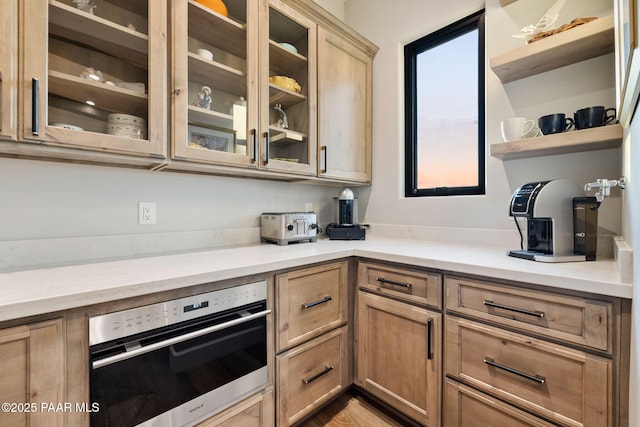 15425 N Talking Rock Ranch Rd, Prescott, AZ 86305 - kitchen featuring stainless steel oven, open shelves, glass insert cabinets, light brown cabinets, and light stone counters