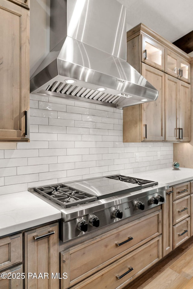 15425 N Talking Rock Ranch Rd, Prescott, AZ 86305 - kitchen with wall chimney exhaust hood, stainless steel gas stovetop, backsplash, light countertops, and glass insert cabinets