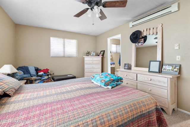 bedroom with a wall mounted AC, light carpet, connected bathroom, and ceiling fan