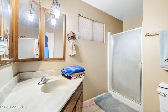 bathroom featuring tile patterned floors, toilet, an enclosed shower, and vanity