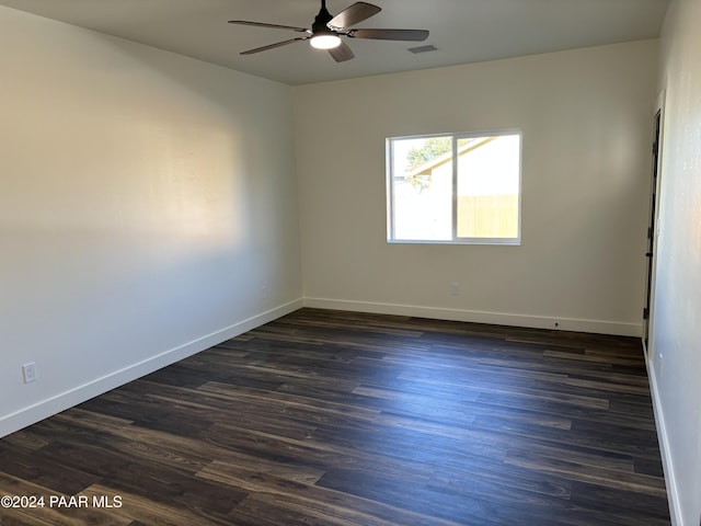 spare room with dark wood-type flooring and ceiling fan