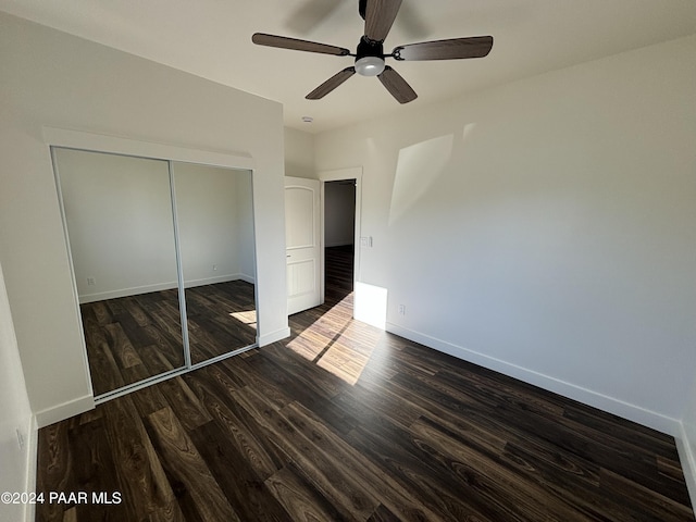 unfurnished bedroom featuring ceiling fan, dark hardwood / wood-style flooring, and a closet