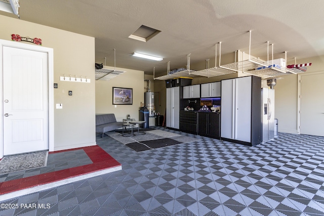 5220 Peavine View Trl, Prescott, AZ 86301 - garage with baseboards, gas water heater, and stainless steel refrigerator with ice dispenser