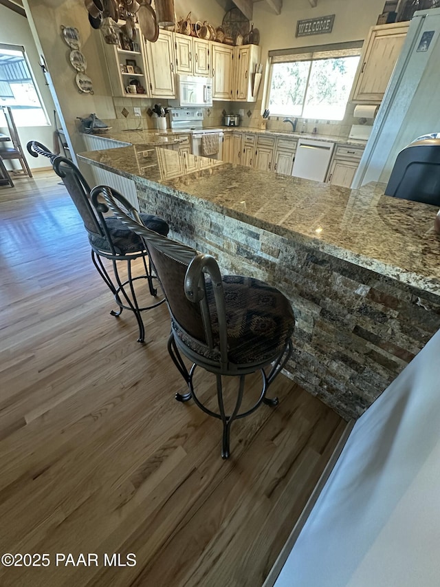 13502 S Burton Rd, Mayer, AZ 86333 - kitchen featuring white appliances, wood finished floors, backsplash, and a kitchen breakfast bar