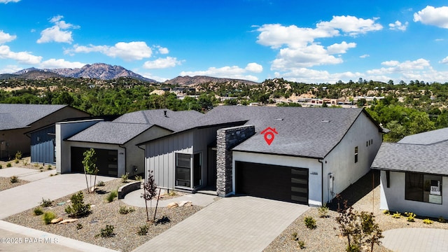 view of front of house with an attached garage, board and batten siding, concrete driveway, and a mountain view