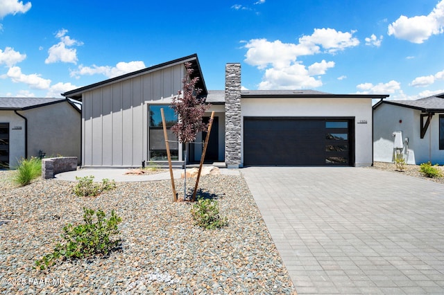 view of front facade with a garage, stucco siding, and decorative driveway