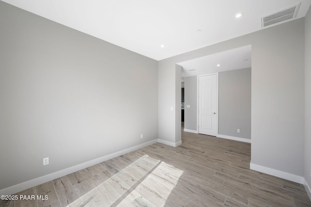 empty room featuring recessed lighting, visible vents, light wood-type flooring, and baseboards
