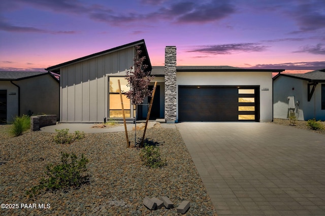 view of front of house with stucco siding, decorative driveway, and an attached garage