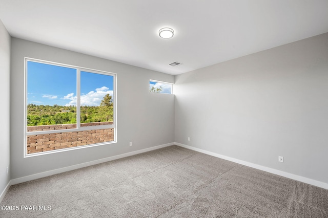 carpeted spare room featuring visible vents and baseboards