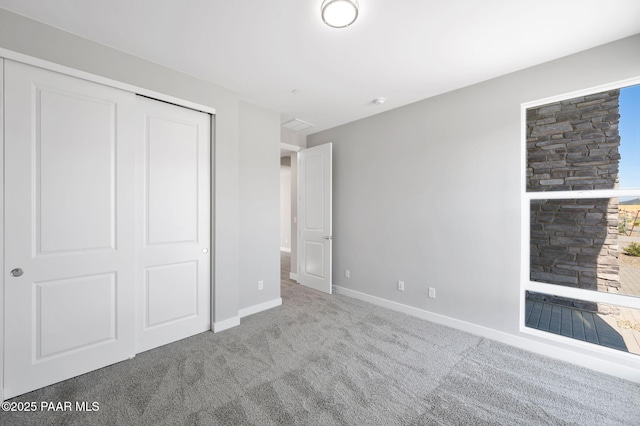 unfurnished bedroom with a closet, baseboards, and carpet