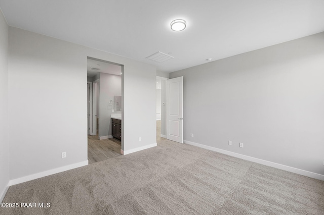unfurnished bedroom with light colored carpet, baseboards, visible vents, and connected bathroom