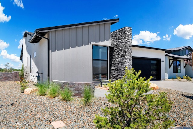 view of front facade with concrete driveway, board and batten siding, and an attached garage
