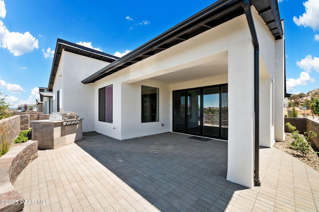 view of patio featuring a fenced backyard, exterior kitchen, and area for grilling