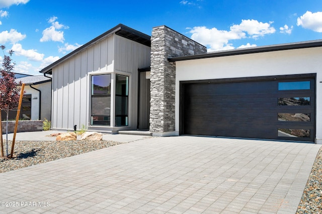 contemporary home featuring board and batten siding, a garage, and driveway