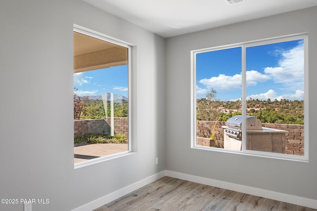 spare room featuring visible vents, baseboards, and wood finished floors