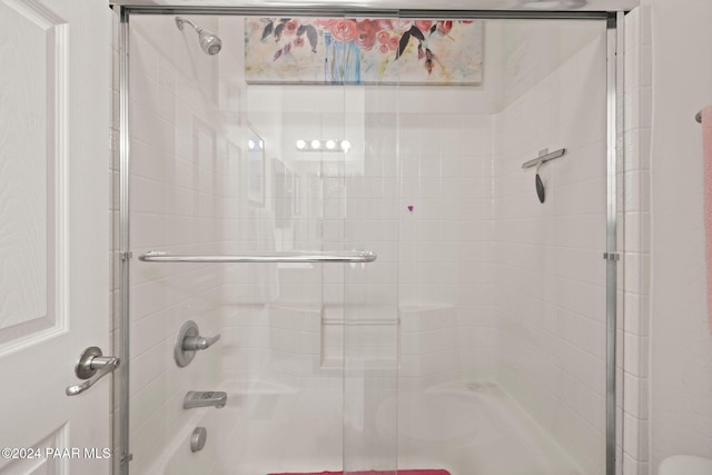 bathroom featuring bath / shower combo with glass door
