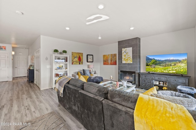 living room featuring light hardwood / wood-style floors and a tiled fireplace