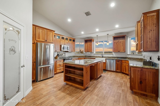 16025 N Hereford Rd, Chino Valley, AZ 86323 - kitchen featuring appliances with stainless steel finishes, open shelves, brown cabinetry, vaulted ceiling, and a kitchen island