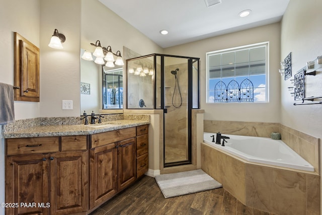 bathroom with vanity, a shower stall, a garden tub, and wood finished floors