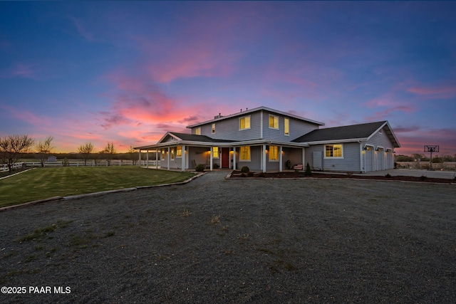 view of front of home featuring a front lawn, fence, covered porch, dirt driveway, and an attached garage