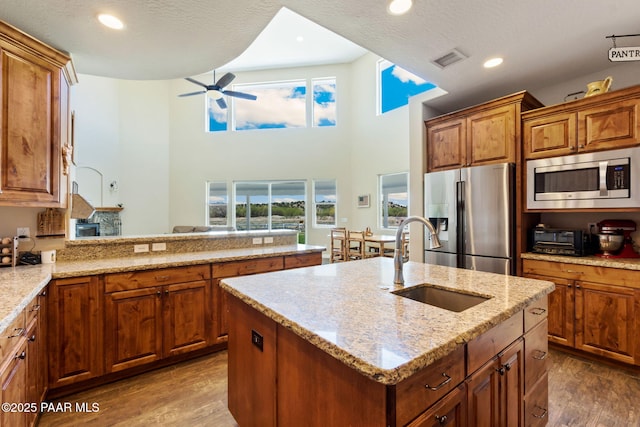 kitchen featuring a ceiling fan, visible vents, appliances with stainless steel finishes, a sink, and dark wood-style floors