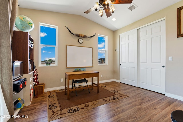 office area with a ceiling fan, baseboards, wood finished floors, lofted ceiling, and visible vents